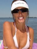 Seaside girl Lori Anderson in white bikini rubs tanning oil on her hairy arms