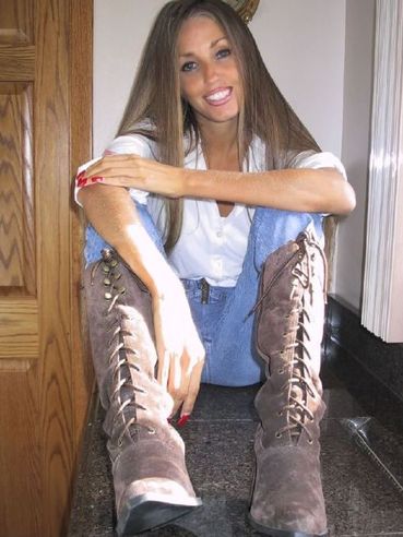 Charming Lori Anderson in white blouse blue, jeans and brown boots shows off her ultra long hair