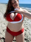 Flirtatious big titted fattie Maria Verbeck poses in red bikini on the beach