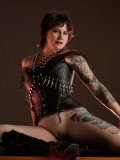 Michelle Aston dressed in leather and latex demonstrates her shaved snatch and tattoos