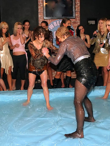 Clothed Leony April does her best to win in oil wrestling match at the all-girl party