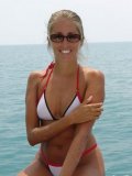 Bikini girl Lori Anderson in sunglasses shows off her long blond arm hair in the sea
