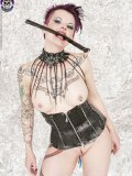 Tattooed alternative model Nixon Sixx poses in tight black leather corset