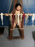 Oriental Angela Decorative with small tits and hairless snatch gets tied to special construction