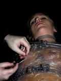 Wrapped Dia Zerva gets drops of hot wax on her nipples after mummification.
